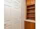 Hallway featuring a white door and a built-in wooden bookcase, offering functional storage and classic style at 13495 Se 93Rd Court Rd, Summerfield, FL 34491