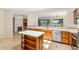 Kitchen featuring a breakfast bar, wooden cabinetry, and views to the living area at 13495 Se 93Rd Court Rd, Summerfield, FL 34491