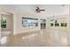 Bright living room boasts tile flooring, a ceiling fan, and large windows overlooking the backyard at 13495 Se 93Rd Court Rd, Summerfield, FL 34491