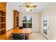 Office with custom built-ins, ample natural light, and serene views of the golf course at 13495 Se 93Rd Court Rd, Summerfield, FL 34491