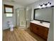 Cozy bathroom with hardwood floors, a wood cabinet vanity and a glass stall shower at 14117 Sw 115Th Cir, Dunnellon, FL 34432