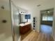 Clean bathroom featuring a wood cabinet vanity, a shower and an adjacent room at 14117 Sw 115Th Cir, Dunnellon, FL 34432
