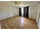 An open bedroom featuring a ceiling fan, hardwood floors, and window with light-blocking curtains at 14117 Sw 115Th Cir, Dunnellon, FL 34432