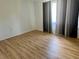 Bright bedroom with light hardwood floors and a window with dark grey-toned curtains at 14117 Sw 115Th Cir, Dunnellon, FL 34432