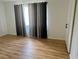 Bedroom with hardwood flooring, an open window, and a closed white door at 14117 Sw 115Th Cir, Dunnellon, FL 34432