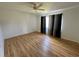 Light-filled bedroom with wood-look flooring, large window, and neutral-toned curtains at 14117 Sw 115Th Cir, Dunnellon, FL 34432