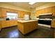 Spacious kitchen with wooden cabinets, stainless steel appliances, and central island, illuminated by natural light at 14117 Sw 115Th Cir, Dunnellon, FL 34432