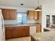 Functional kitchen featuring wood cabinets, white appliances, and a view to the backyard at 14117 Sw 115Th Cir, Dunnellon, FL 34432
