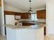 Well-lit kitchen with wood cabinets, peninsula counter, and modern pendant lighting at 14117 Sw 115Th Cir, Dunnellon, FL 34432