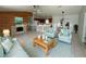 Bright open-concept living room with wood-paneled wall, fireplace, and adjoining kitchen and dining area at 14117 Sw 115Th Cir, Dunnellon, FL 34432
