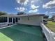 Backyard featuring synthetic grass, a privacy fence, and mature landscaping at 14117 Sw 115Th Cir, Dunnellon, FL 34432