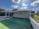 Home exterior with synthetic grass backyard, screened-in lanai and retractable awning at 14117 Sw 115Th Cir, Dunnellon, FL 34432
