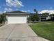 Charming single-story home with a well-manicured lawn, a two-car garage, and beautiful landscaping at 14117 Sw 115Th Cir, Dunnellon, FL 34432