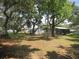 View of the backyard with mature trees, lush grass, and accessory buildings at 1675 Se 190Th Ave, Silver Springs, FL 34488