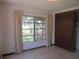 Bedroom with closet, neutral walls, large windows with nature views and neutral curtains at 1675 Se 190Th Ave, Silver Springs, FL 34488