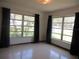 Bedroom with large windows and dark curtains, offering natural light and a view of the outdoors at 1675 Se 190Th Ave, Silver Springs, FL 34488