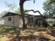 Home exterior with a brown roof, mature tree with thick branches, and multiple windows at 1675 Se 190Th Ave, Silver Springs, FL 34488
