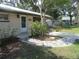 Home's front entrance featuring a stone walkway, mature trees, and a brown garage door at 1675 Se 190Th Ave, Silver Springs, FL 34488