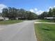 A paved neighborhood street view surrounded by lush greenery and blue skies at 1675 Se 190Th Ave, Silver Springs, FL 34488