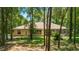 Backyard view with covered patio, mature trees and green grass lawn at 18328 Sw 73Rd Loop, Dunnellon, FL 34432