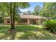 Backyard view with covered patio, mature trees and green grass lawn at 18328 Sw 73Rd Loop, Dunnellon, FL 34432