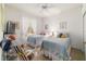 Cozy bedroom featuring two twin beds, a ceiling fan, and natural light from the window at 18328 Sw 73Rd Loop, Dunnellon, FL 34432