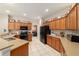 Spacious kitchen features wooden cabinets, black appliances, and ample countertop space at 18328 Sw 73Rd Loop, Dunnellon, FL 34432