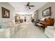 Bright living room with neutral walls, and tile and carpet flooring features a piano and views to the formal dining room at 18328 Sw 73Rd Loop, Dunnellon, FL 34432
