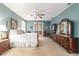 Spacious main bedroom features neutral carpet, French doors, ceiling fan, and dresser with vanity mirror at 18328 Sw 73Rd Loop, Dunnellon, FL 34432