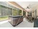 Relaxing screened in patio with a hot tub, ceiling fan and dining table at 18328 Sw 73Rd Loop, Dunnellon, FL 34432