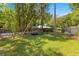 Large, green backyard with lush landscaping, fenced garden beds, and mature trees, offering plenty of space at 200 Se 145Th St, Summerfield, FL 34491