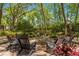 Private backyard fire pit area surrounded by lush trees and landscaping, perfect for outdoor entertaining and relaxation at 200 Se 145Th St, Summerfield, FL 34491