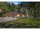 Beautiful single-story home featuring a circular driveway, lush landscaping, and mature trees at 200 Se 145Th St, Summerfield, FL 34491