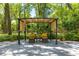Outdoor lounge area featuring comfortable seating beneath a pergola, surrounded by greenery, perfect for relaxation at 200 Se 145Th St, Summerfield, FL 34491