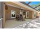 Covered patio with an outdoor dining area, ceiling fan, decorative art, and access to the home and pool at 200 Se 145Th St, Summerfield, FL 34491