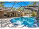 Screened-in pool featuring a waterfall feature, outdoor seating, and access to the home, perfect for relaxation at 200 Se 145Th St, Summerfield, FL 34491