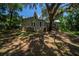 An outside angle showing the back of the house, with metal roof and a large tree at 20549 9Th St, Mc Intosh, FL 32664