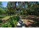 Lush backyard with mature trees, open lawn, and a pathway, perfect for relaxation and recreation at 20549 9Th St, Mc Intosh, FL 32664