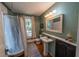 Vintage bathroom features a classic pedestal sink, tub with shower, hardwood floors, and natural light at 20549 9Th St, Mc Intosh, FL 32664