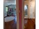 View through hallway showcasing wood and tile flooring, a charming bedroom and access to a full bathroom at 20549 9Th St, Mc Intosh, FL 32664