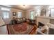Cozy living room featuring a fireplace, wooden floors, natural lighting, and a decorative rug at 20549 9Th St, Mc Intosh, FL 32664