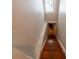 View down the stairs showing the hardwood steps, marble railing, and tiled landing at the bottom at 20549 9Th St, Mc Intosh, FL 32664