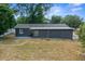 Back view of home featuring gray exterior, patio and large grassy backyard at 219 Marion Oaks Ln, Ocala, FL 34473