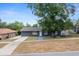 Exterior view of home with large tree, well, driveway, and landscaped yard at 219 Marion Oaks Ln, Ocala, FL 34473