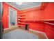 Laundry room featuring orange accent wall, tile flooring, and open shelving at 219 Marion Oaks Ln, Ocala, FL 34473