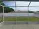 View of the backyard from the screened in lanai with a well-maintained lawn and a white fence at 2909 Ne 25Th St, Ocala, FL 34470