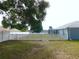 Large backyard featuring a manicured lawn, white picket fence, and mature shade trees at 2909 Ne 25Th St, Ocala, FL 34470