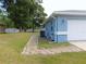 Home exterior featuring a side yard with a stone pathway, garage and well-maintained landscaping at 2909 Ne 25Th St, Ocala, FL 34470
