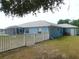 Exterior view of home featuring a well-maintained yard, white fence and a screened-in lanai at 2909 Ne 25Th St, Ocala, FL 34470