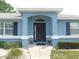 Charming home entrance with elegant black door, complemented by decorative flower pots and manicured landscaping at 2909 Ne 25Th St, Ocala, FL 34470